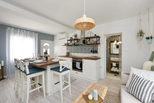 een keuken en een woonkamer met een tafel en stoelen bij Apartment Nemo in Zadar