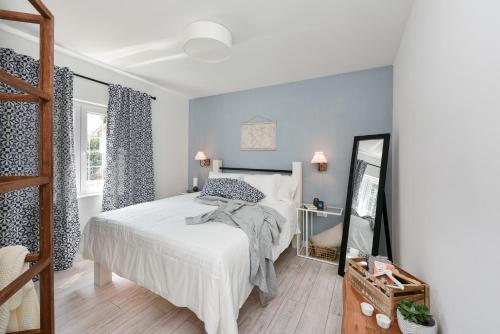 een slaapkamer met een wit bed en een spiegel bij Apartment Nemo in Zadar