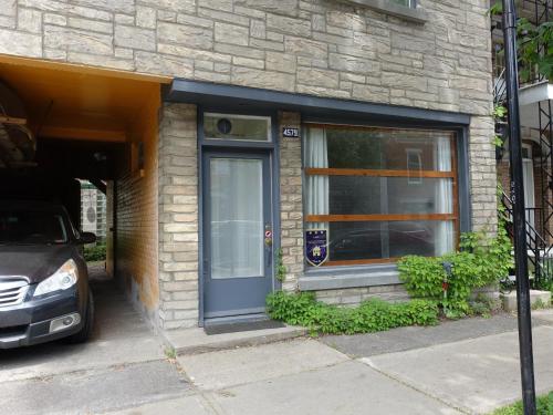 a front door of a house with a car parked outside at Gite à Coté in Montréal