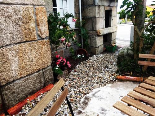 a garden with a bench next to a building at Mar de Rosas in O Grove
