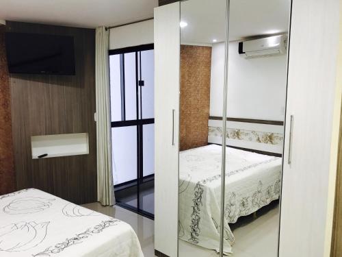 a bedroom with a bed and a sliding glass door at Apartamento 401 Edificio London in Piratuba