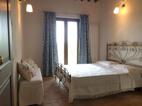 a bedroom with a bed and a window at Il Nido del Falco nelle Antiche Mura in Saturnia