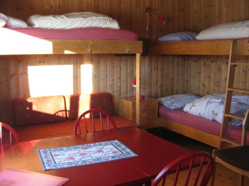 a room with two bunk beds and a table and chairs at Putten Seter in Høvringen