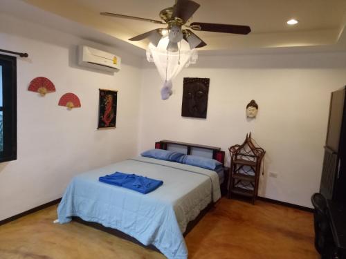 a bedroom with a bed and a ceiling fan at Bee Nat Garden Resort in Bangrak Beach