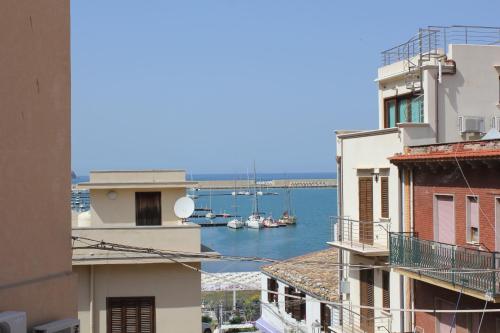 a view of a harbor from between buildings at B&B Da Peppa in Castellammare del Golfo