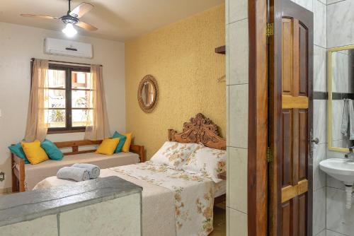 1 dormitorio con cama, lavabo y ventana en Adora Suites, en Abraão