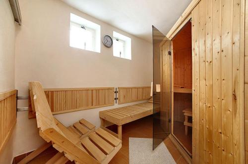 un sauna avec un banc et une horloge sur le mur dans l'établissement Ubytování Bezchlebovi, à Český Krumlov