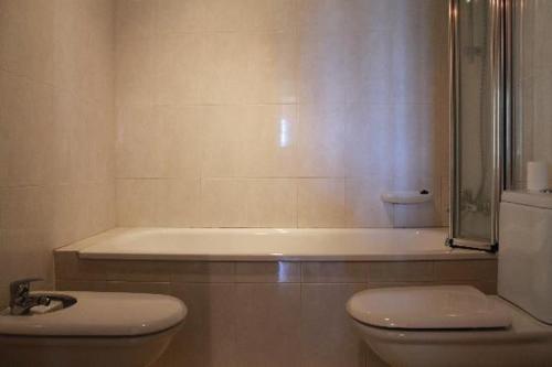 a bathroom with a shower and a toilet and a tub at Villa Catalana in Calonge