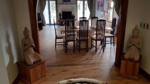 a dining room with a table and chairs with statues at Bruntwoodlodge in Cambridge