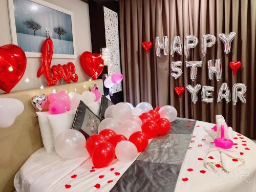 a room with a table with balloons and a happy year sign at Muine Sports Hotel in Mui Ne