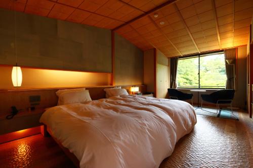 a large white bed in a room with a window at Nanzenji sando KIKUSUI in Kyoto