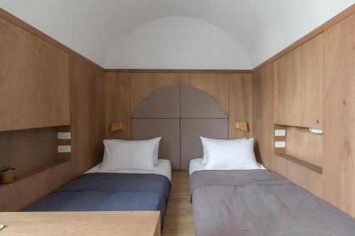 two beds in a room with wooden walls at Ho̍k House in Kaohsiung