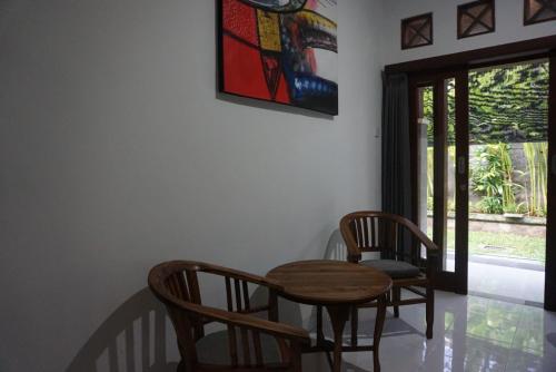 a dining room with a table and chairs and a window at Mai Guesthouse in Sanur