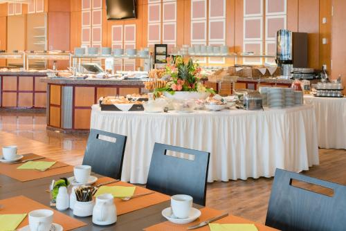a table with a white tablecloth and chairs in a restaurant at Best Western Plus Hotel Am Schlossberg in Nürtingen