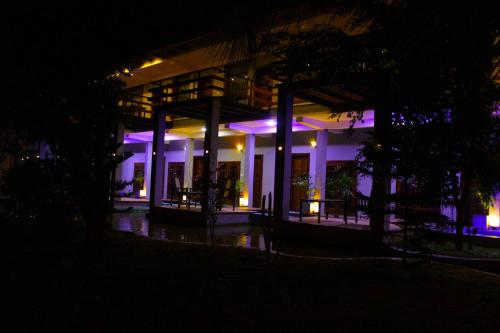 a building lit up at night with purple lights at Hotel Green Garden in Trincomalee