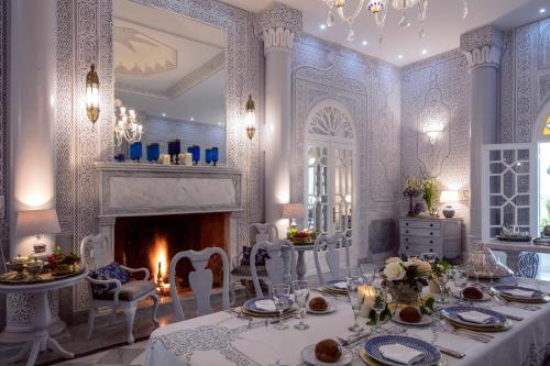 a dining room with a table and a fireplace at Riad Dar El Malaika in El Jadida