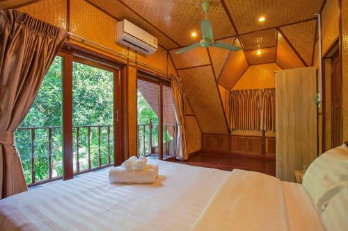 a bedroom with a large bed with a large window at Tropical Family Retreat near Ya Nui Beach - Villa Nikkie in Nai Harn Beach