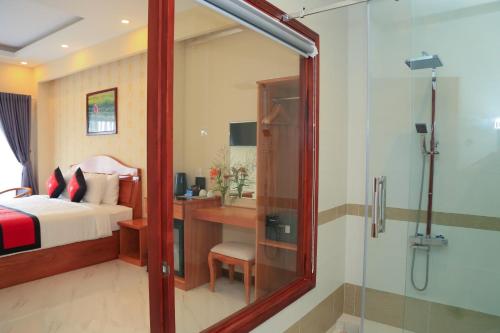 a bedroom with a bed and a desk and a shower at Van Kim Long in Ấp Ðông Quì