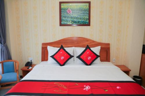 a bedroom with a bed with red and black pillows at Van Kim Long in Ấp Ðông Quì