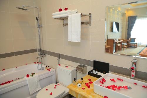 a bathroom with a toilet and a tub and a sink at Van Kim Long in Ấp Ðông Quì