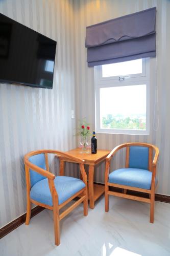 a dining room table with two chairs and a television at Van Kim Long in Ấp Ðông Quì