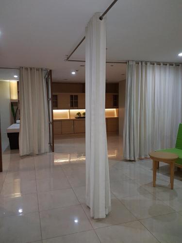 a living room with white curtains and a green chair at Mactan Newtown Ocean View 360 Degree in Mactan