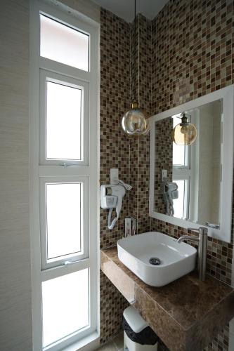 a bathroom with a sink and a mirror at Homeland Hotel in Da Lat