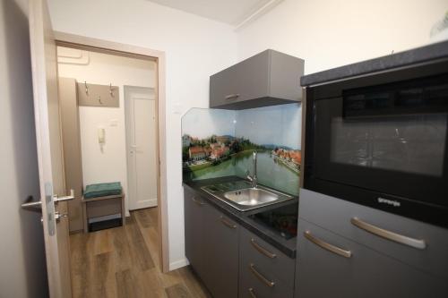 a kitchen with a sink and a microwave at Elegant central Apt Maribor w/Parking in Maribor