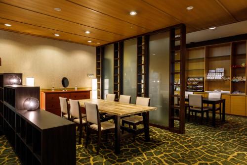 a dining room with a wooden table and chairs at Hotel JAL City Nagano in Nagano