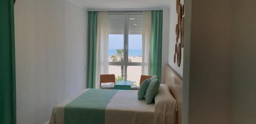1 dormitorio con ventana y vistas a la playa en El Globo, en Valencia