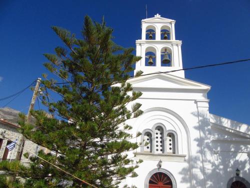 a white church with a christmas tree in front of it at Magnificent traditional house in the centre of Naxos in Khalkíon