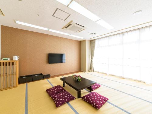 a room with two chairs and a table and a tv at Hotel Abest Naha Kokusai Street in Naha