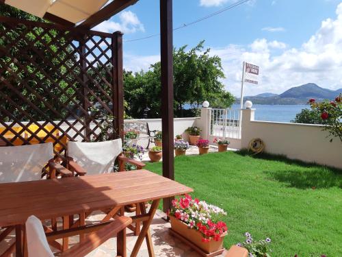 a patio with a wooden table and a view of the water at Irini seaside studios in Nikiana