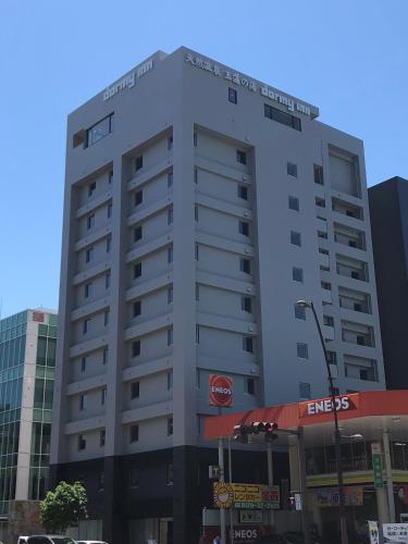 a tall white building with a stop sign on it at Dormy Inn Takamatsu Chuo Koenmae Natural Hot Spring in Takamatsu