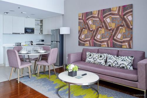 a living room with a purple couch and a table at Citadines Millennium Ortigas Manila in Manila