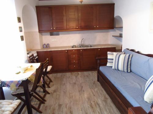 a living room with a couch and a table and a kitchen at Magnificent traditional house in the centre of Naxos in Khalkíon