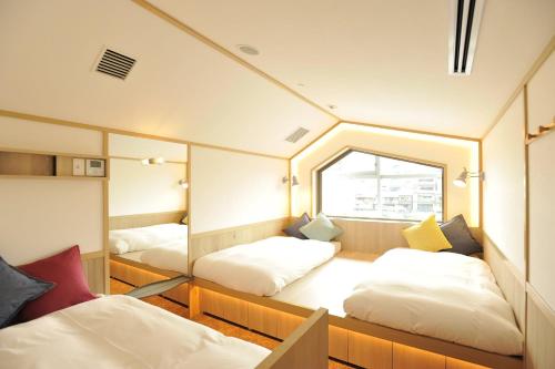 Postel nebo postele na pokoji v ubytování CAFETEL Kyoto Sanjo for Ladies