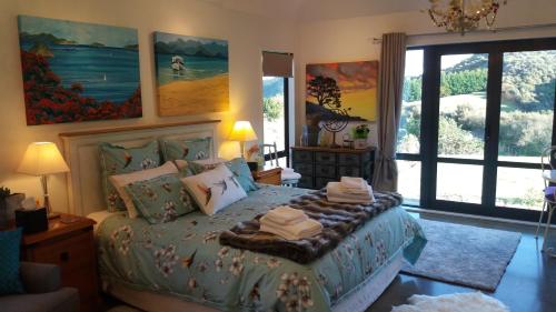 a bedroom with a bed with towels on it at Boutique Art Retreat in Upper Hutt