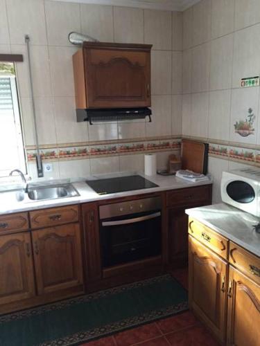 a kitchen with a sink and a stove top oven at Quinta dos Espinheiros in Provesende