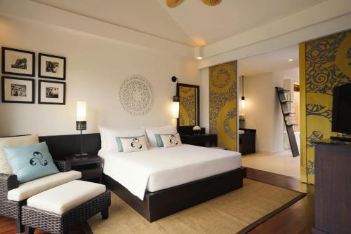 a hotel room with a bed and a chair at Mövenpick Asara Resort & Spa Hua Hin in Hua Hin