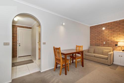 a kitchen and dining room with a table and a couch at Golden Square Motor Inn in Bendigo