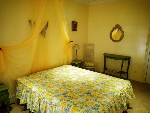 een slaapkamer met een bed en een spiegel aan de muur bij Chambre d'Hôte Couguiolet - avec piscine in Foissac