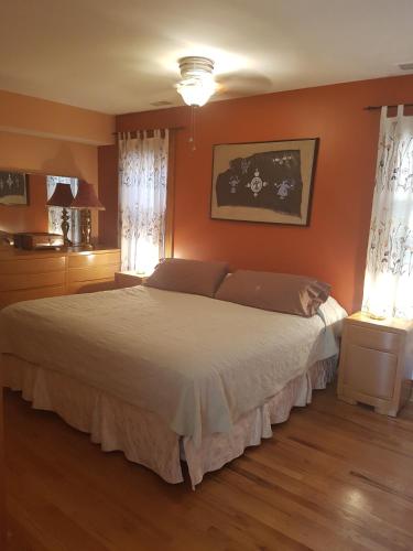 a bedroom with a large bed with orange walls at Superior in Chicago