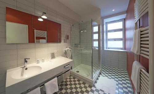 a bathroom with a sink and a shower at MOMA1890 Boutique Hotel in Munich