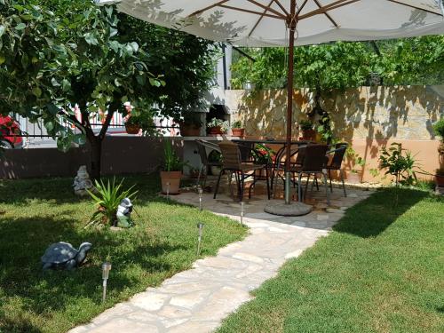 un patio con mesa y sillas bajo una sombrilla en Apartments Toni, en Zadar