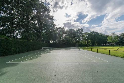 a tennis court in a park with clouds in the sky at Villa Kempen-Broek in Weert