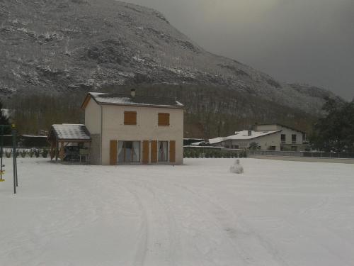 a house in the snow in front of a mountain at La Résidence de Lorelei in Cierp