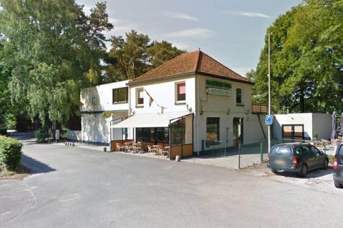 a building with a car parked next to a street at Villa Kempen-Broek in Weert