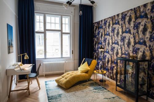 a living room with a yellow couch in front of a wall at Sophie's Art Home Broadway Budapest in Budapest