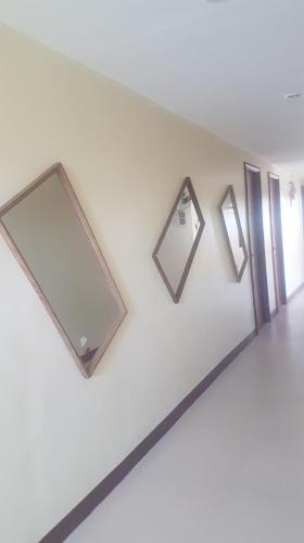 a room with three mirrors on a white wall at Haus Of Tubo Davao in Davao City